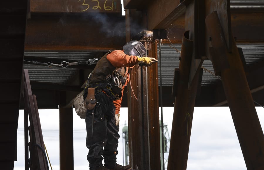A welder works on a brace frame on the sixth floor of the seven-story office tower at the Vancouver waterfront in March. An upsurge in construction positions helped drive a 400-job increase in seasonally adjusted Clark County employment in March.