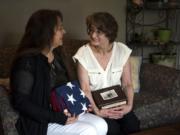 Yvonne Ortega, left, and her mother, Barbara Jo Payne, both of Vancouver, hold Wathen Curtsinger’s ashes and memorial flag Monday at Payne’s home. Curtsinger, Payne’s father and Ortega’s grandfather, was a World War II Marine veteran. He died in 1996, and his ashes were lost in 2002, stolen during a family move. Marine veteran Bill Malloy, a member of Veterans of Foreign Wars Post 1927, was the link between the family and the Woodland Police Department.