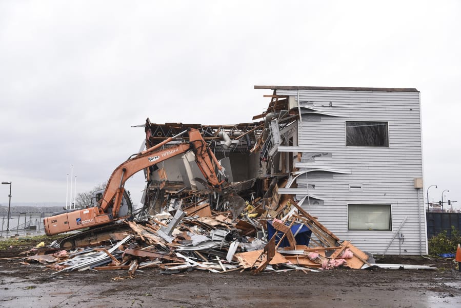 A bulldozer tears down The Columbia Shores office building near the Columbia River on Thursday. Like parts of the Red Lion Hotel Vancouver at the Quay, it was built in the 1960s and torn down to make room for the Port of Vancouver’s upcoming waterfront projects.