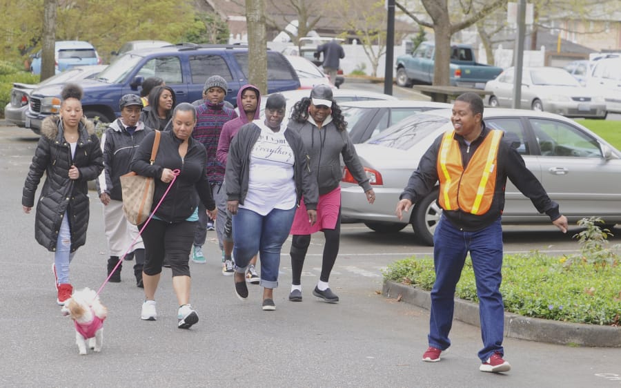 Gerald Dory, right, leads a neighborhood walk during a Let’s Get Moving meeting. The program is a culture-specific program that takes aim at health disparities among black people.