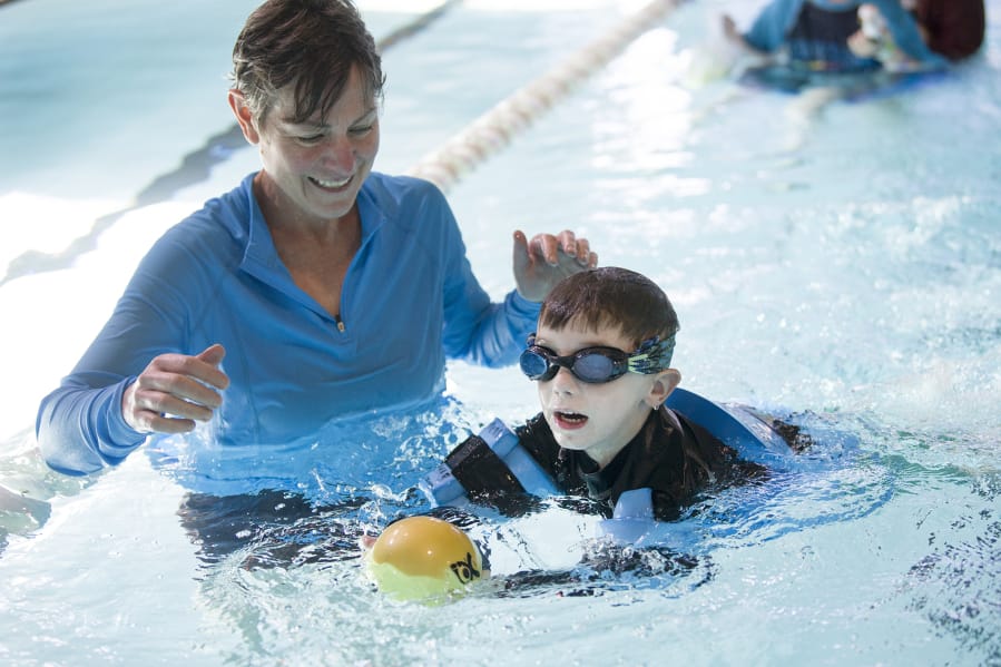 Occupational therapist Karen Drogos, left, helps Gary Silvas, 5, swim to capture a ball during a water-based physical therapy session at the Marshall Center. Gary was a micro-preemie and weighed just 1 pound, ½ ounce at birth.