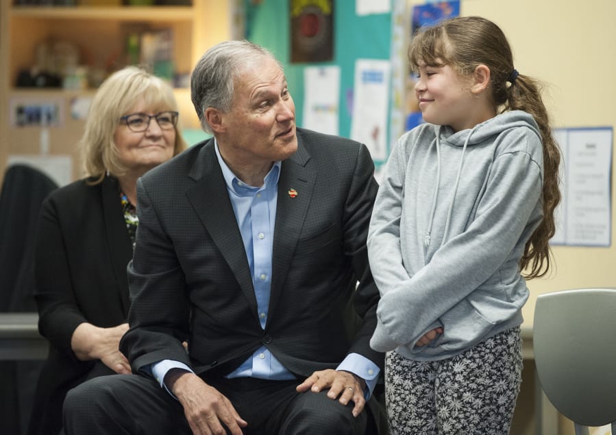 Gov. Jay Inslee talks to third-grader Anaiyah Andre, 9, before naming her Washingtonian of the Day, recognizing her for her creative answer to a question he’d asked. Inslee, a Democrat, kicked off a Monday visit to Vancouver with a stop at Fruit Valley Community Learning Center to talk about the Breakfast After the Bell bill and learn what the school is doing to support students and the community. First lady Trudi Inslee is seated behind her husband.