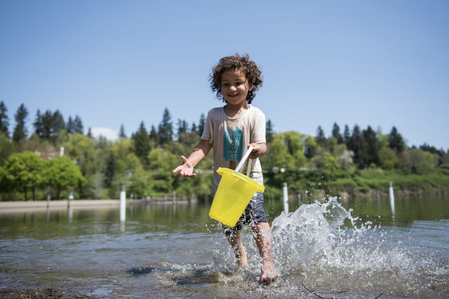 Lincoln Maldonado of Vancouver, 3, plays in the water at Klineline Pond in Vancouver on Wednesday afternoon, April 25, 2018. Temperatures reached record-breaking numbers in the low 80s this week, but are predicted to fall back to the 50s on Friday.
