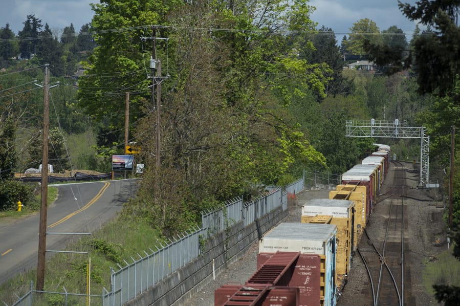 A BNSF Railways train passes a housing subdivision under construction on Northwest 69th Street along Vancouver Lake. BNSF is suing Vancouver Cove, an Oregon-based land developer, accusing the company of encroaching on its operating corridor, tearing down a fence and doing some construction work.