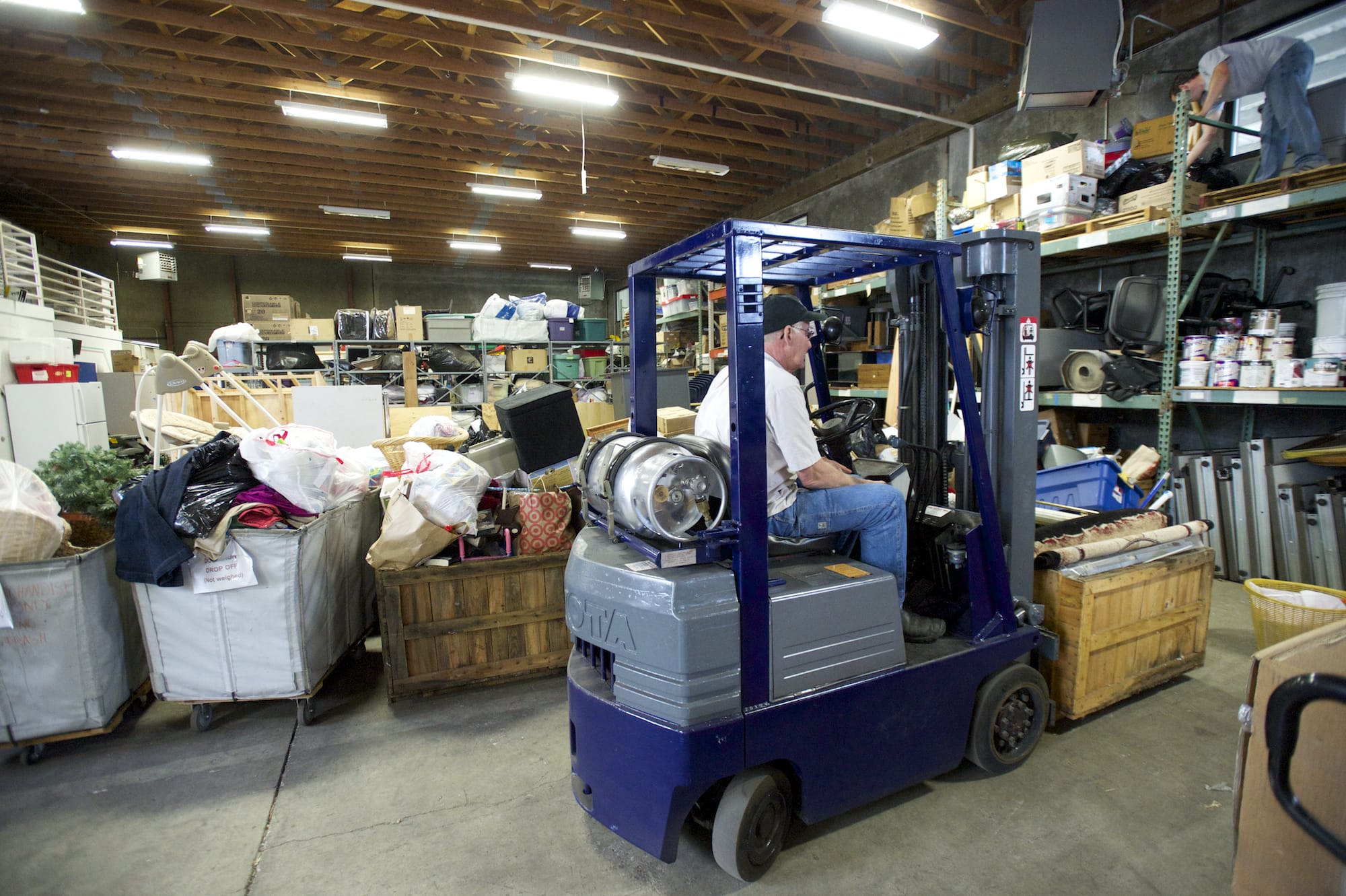 Warehouse workers organize donated goods at the ARC storage facility in 2014. The organization hopes to open a retail space in Vancouver Plaza, which is less than a mile from the storage warehouse.