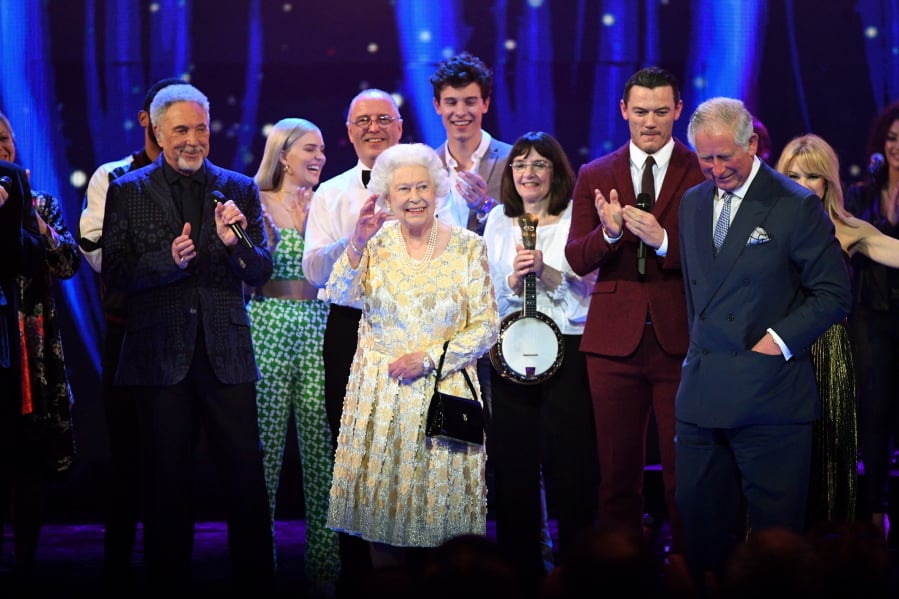 Queen Elizabeth II, center, and Prince Charles stand on stage with Sir Tom Jones, left, and other performers at the Royal Albert Hall in London on Saturday at a concert to celebrate the queen’s 92nd birthday.