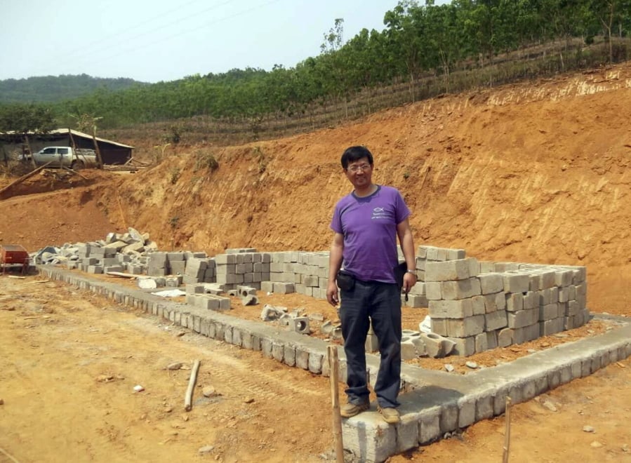 In this May 2014, photo released by Ben Cao, Rev. John Sanqiang Cao breaks a ground on a new school in Wa State, Myanmar.