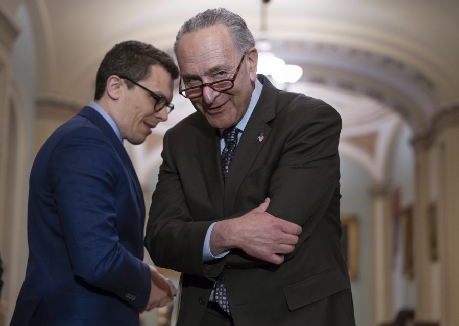 Senate Minority Leader Chuck Schumer, D-N.Y., confers with his communications aide Matt House as he speaks to reporters following a closed-door strategy session on Capitol Hill in Washington, Tuesday, April 17, 2018. (AP Photo/J.