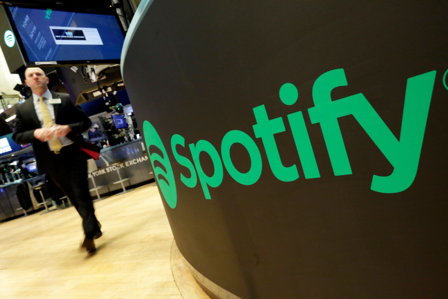 A trading post sports the Spotify logo on the floor of the New York Stock Exchange, Tuesday, April 3, 2018. Spotify, the No. 1 music streaming service which has drawn comparisons to Netflix, is about to find out how it plays on the stock market in an unusual IPO.