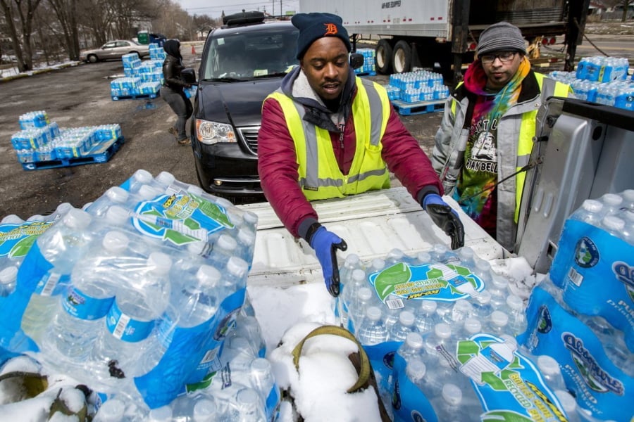 Water distribution employee Albrey Kirkland places cases of water into the back of a pickup Thursday at a water distribution center in Flint, Mich. The centers will operate until the current supply of state-funded bottles run out.