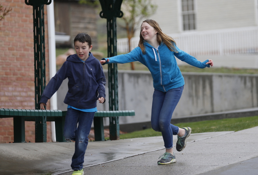 Caleb Coulter, 10, left, and his sister Kendra, 12, play tag during a visit to the Place Heritage Park in Salt Lake City on April 6. Below, Amy Coulter, left, and her daughter April, 7, talk, while playing.