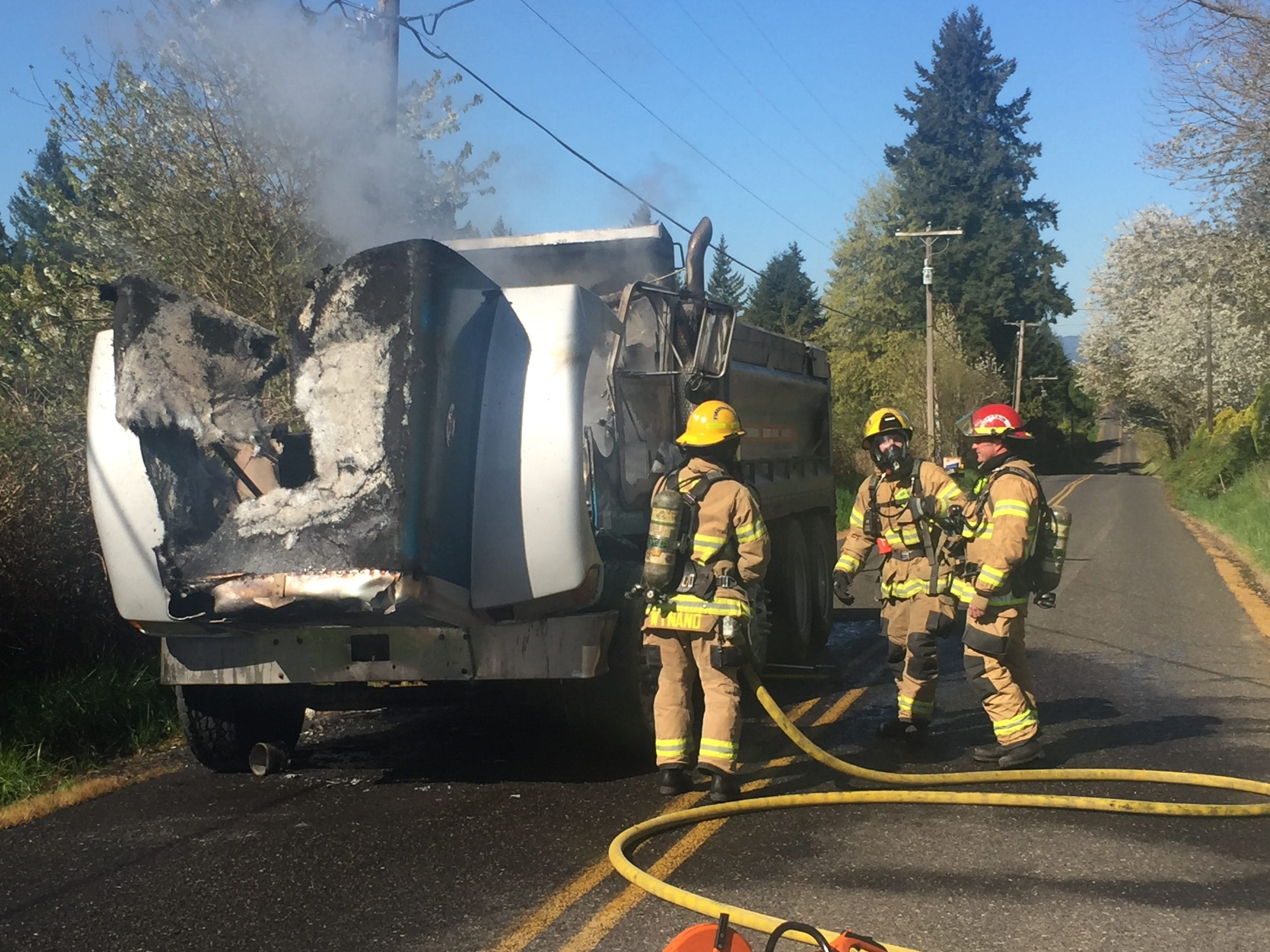 Firefighters with Clark County Fire & Rescue inspect a dump truck that caught fire Thursday morning near the 4500 block of Northwest 199th Street south of Ridgefield.
