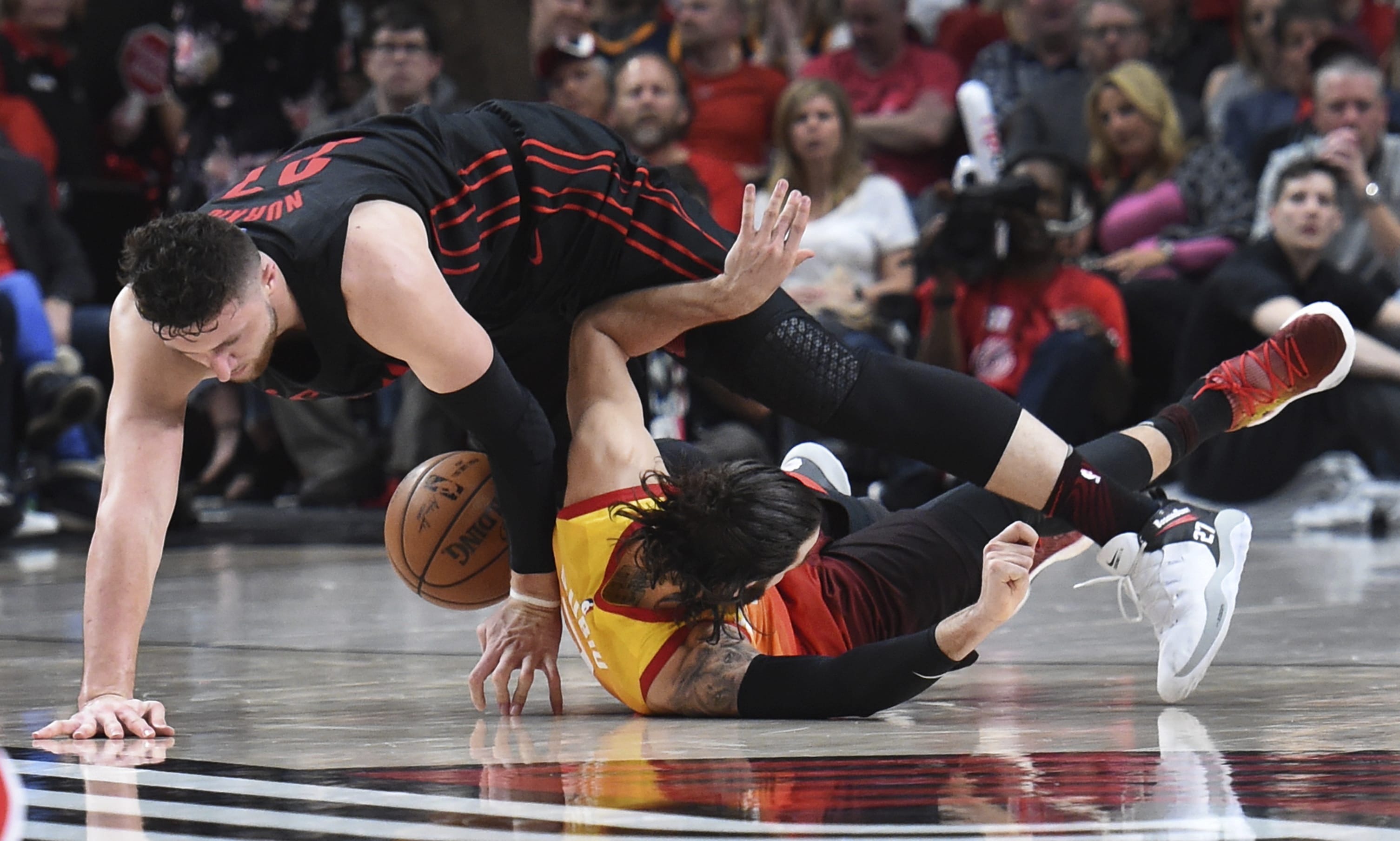 Portland Trail Blazers center Jusuf Nurkic, top, and Utah Jazz guard Ricky Rubio scramble for a ball during the second half of an NBA basketball game in Portland, Ore., Wednesday, April 11, 2018. The Blazers won 102-93.