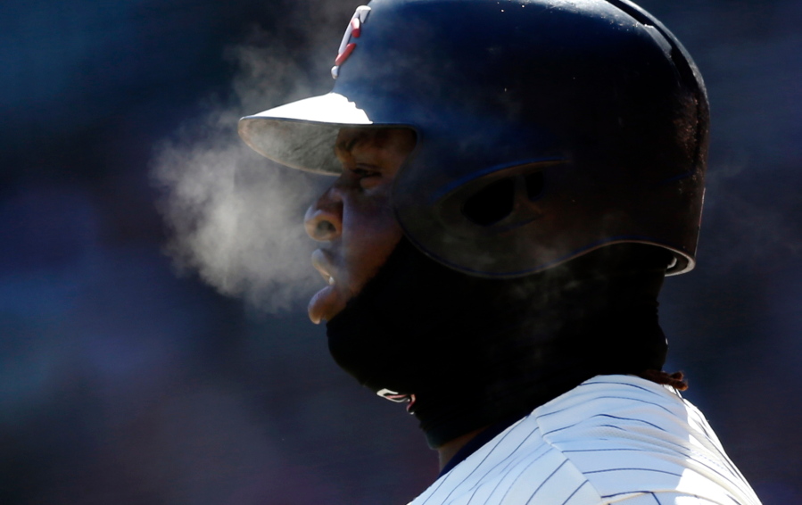 Minnesota Twins’ Miguel Sano generates steam as he breathes with the temperatures in the mid-20’s while on deck in the first inning of a baseball game against the Seattle Mariners Saturday, April 7, 2018, in Minneapolis.