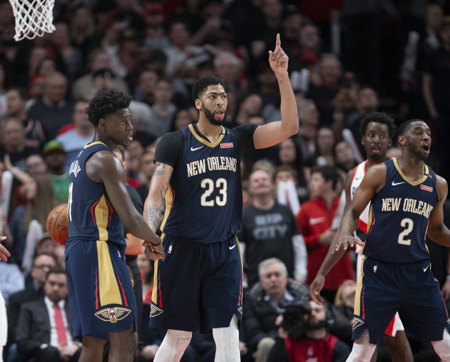 New Orleans Pelicans guard Jrue Holiday, forward Anthony Davis and guard Ian Clark celebrate a score against the Portland Trail Blazers during the second half in Game 1 of an NBA basketball first-round playoff series Saturday, April 14, 2018, in Portland, Ore. New Orleans won 97-95. (AP Photo/Randy L.