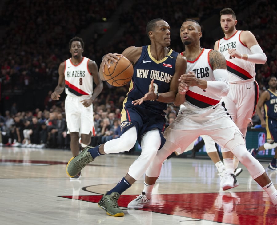 New Orleans Pelicans guard Rajon Rondo, front left, drives against Portland Trail Blazers guard Damian Lillard during the first half in Game 1 of an NBA basketball first-round playoff series Saturday, April 14, 2018, in Portland, Ore. (AP Photo/Randy L.
