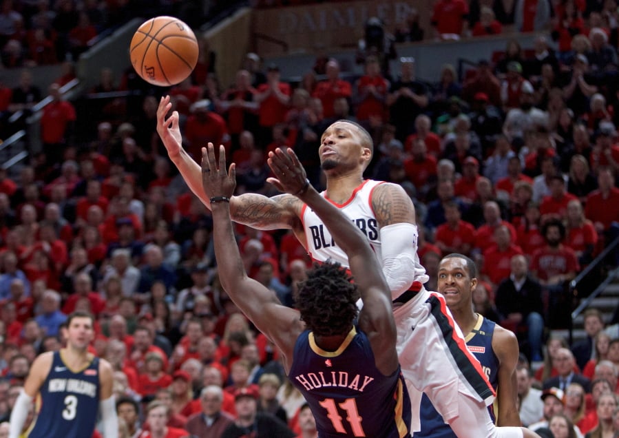 Portland Trail Blazers guard Damian Lillard shoots over New Orleans Pelicans guard Jrue Holiday during the second half of Game 2 of an NBA basketball first-round playoff series Tuesday, April 17, 2018, in Portland, Ore. The Pelicans won 111-102.
