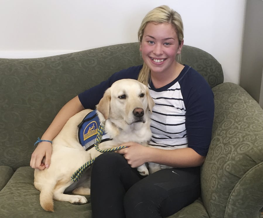 This 2016 photo provided by Ivy Jacobsen, shows Jacobsen of Lake Stevens, Wash., with a facility or comfort dog. She said three facility dogs helped her get through the three trials required before her father was convicted of sexually assaulting her as a teenager. The use of dogs to comfort prosecution witnesses in court is increasing across the country, despite concerns by defense lawyers that the animals can prejudice juries against defendants.