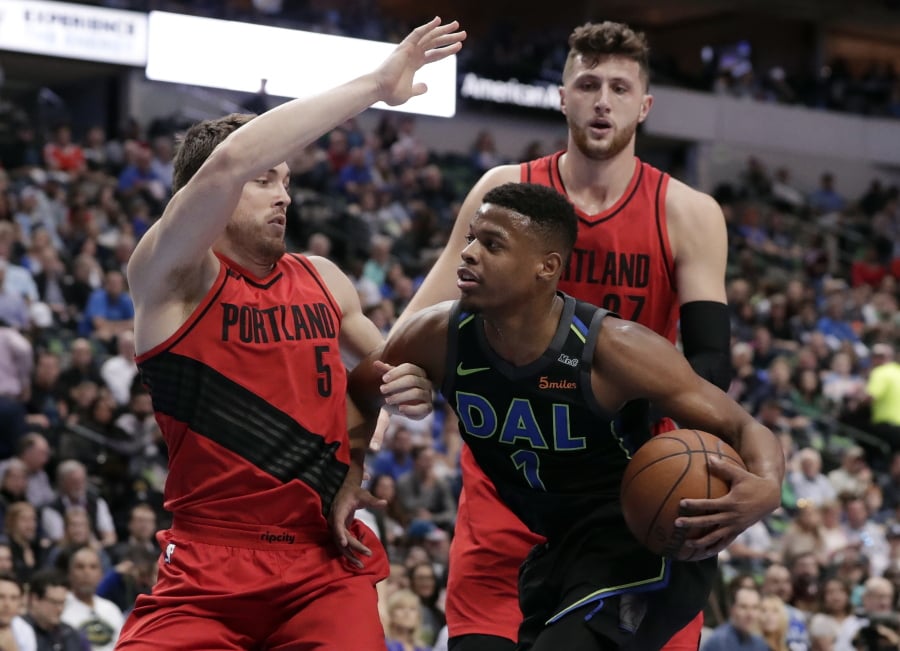 Dallas Mavericks guard Dennis Smith Jr. (1) works to the basket against Portland Trail Blazers’ Pat Connaughton (5) and Jusuf Nurkic, right rear, in the first half of an NBA basketball game in Dallas, Tuesday, April 3, 2018.