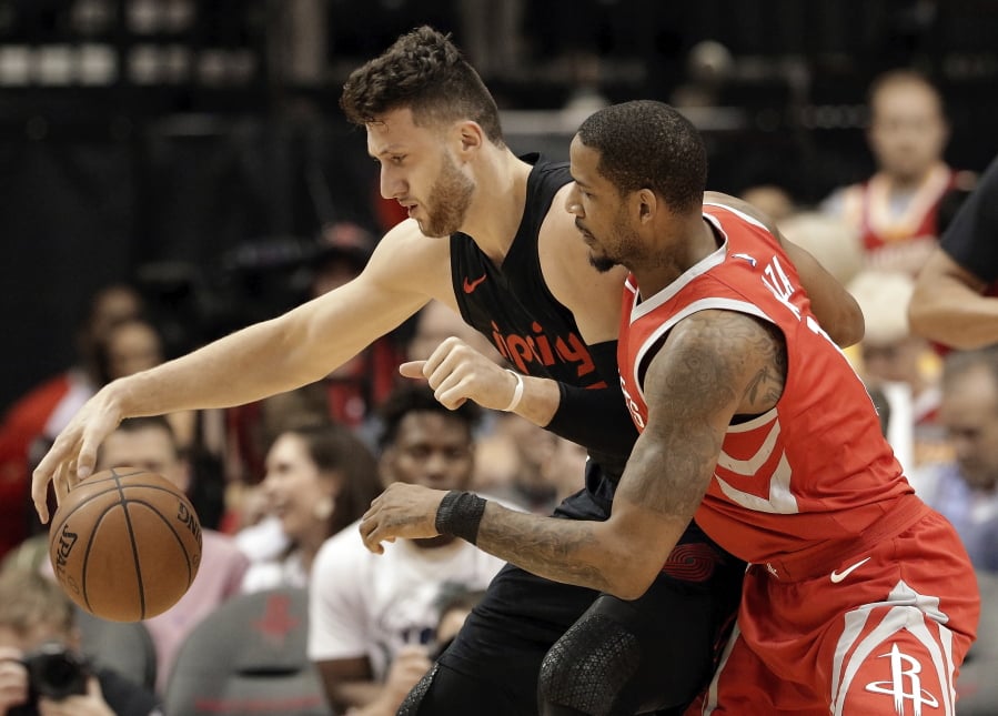 Portland Trail Blazers center Jusuf Nurkic, left, tries to keep control of the ball under pressure from Houston Rockets forward Trevor Ariza, right, during the first half of an NBA basketball game Thursday, April 5, 2018, in Houston.