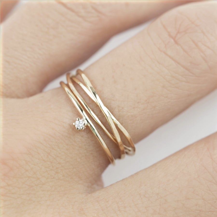 Envero Jewelry’s delicate set of hand-hammered trinity rings, and a 14K gold band with solitaire diamond. The piece reflects a trend toward unique modern bridal jewelry.