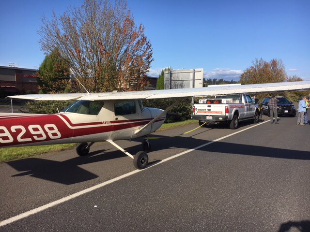 A Washington Department of Transportation emergency response team prepares to tow a single-engine aircraft that landed on state Highway 14 on Saturday afternoon. No injuries were reported.