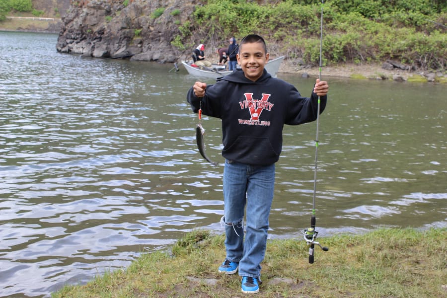 RJ Aparicio, 10, shows off a rainbow trout from Rowland Lake on April 28. Mechanical issues with the hatchery tanker truck meant the lake was not stocked until 11 a.m. on opening day at the Columbia River Gorge lake.