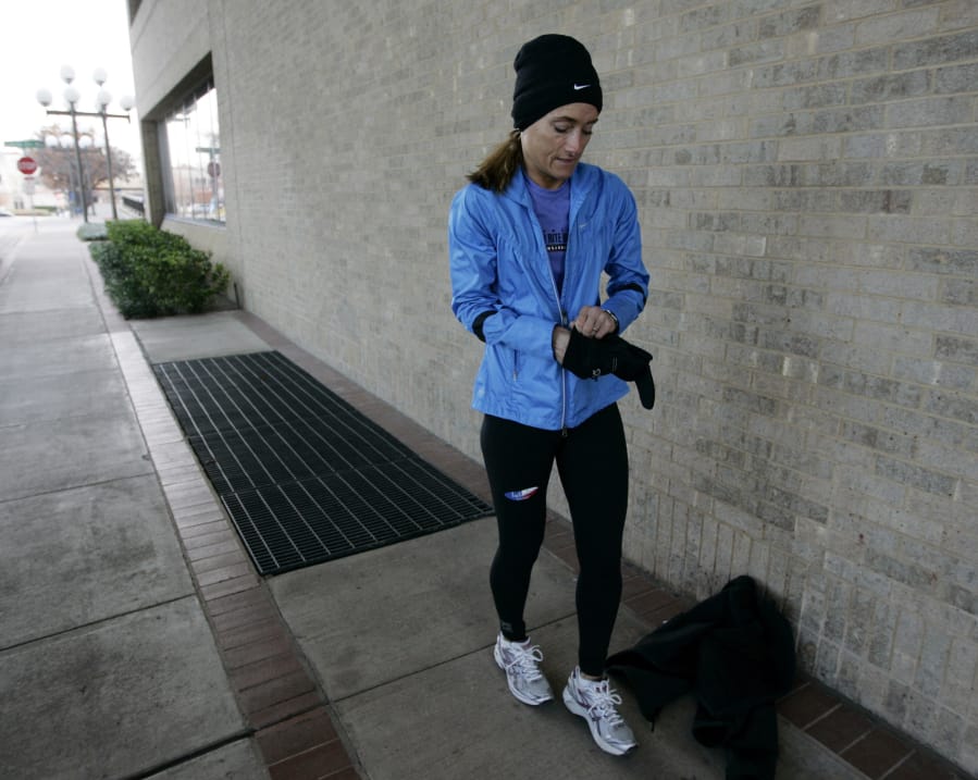 Andi Smith puts on her gloves before beginning a quick run on Dec. 15, 2009. A new discovery determined exercise and shivering both release a molecule into the bloodstream that tells your muscles to start burning fat.
