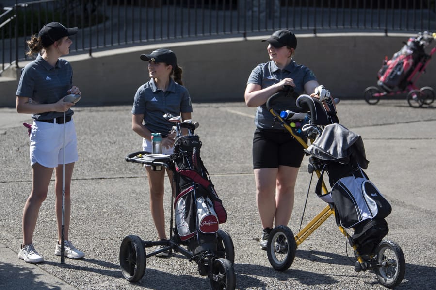 Woodland Middle School eighth-grader Katherine Patnode, left, seventh-grader Lucy Sams, center, and seventh-grader Maryjane Moss, right, wait to tee off during their match against Columbia River High School at Lewis River Golf Course on Thursday, April 26, 2018.