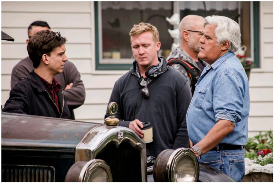 Clayton Paddison, left, a crew member and Jay Leno consult during filming at Paddison’s home on Wednesday morning.