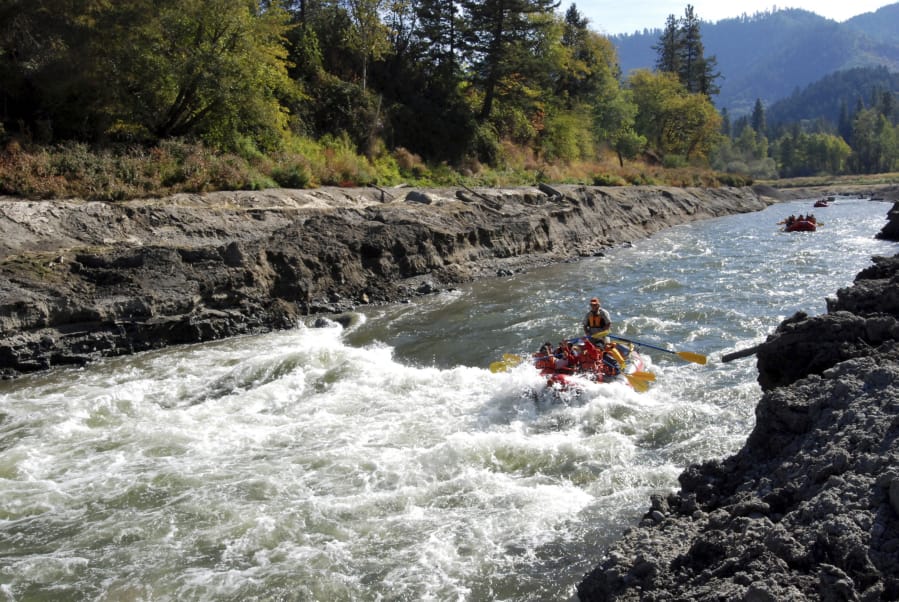 Rafts float on the Rogue River near Rogue River, Ore., in 2009. Water quality advocates filed a lawsuit Tuesday alleging the city of Medford, Ore., discharged water from its sewage treatment plant, harming the Rogue River’s aquatic balance.