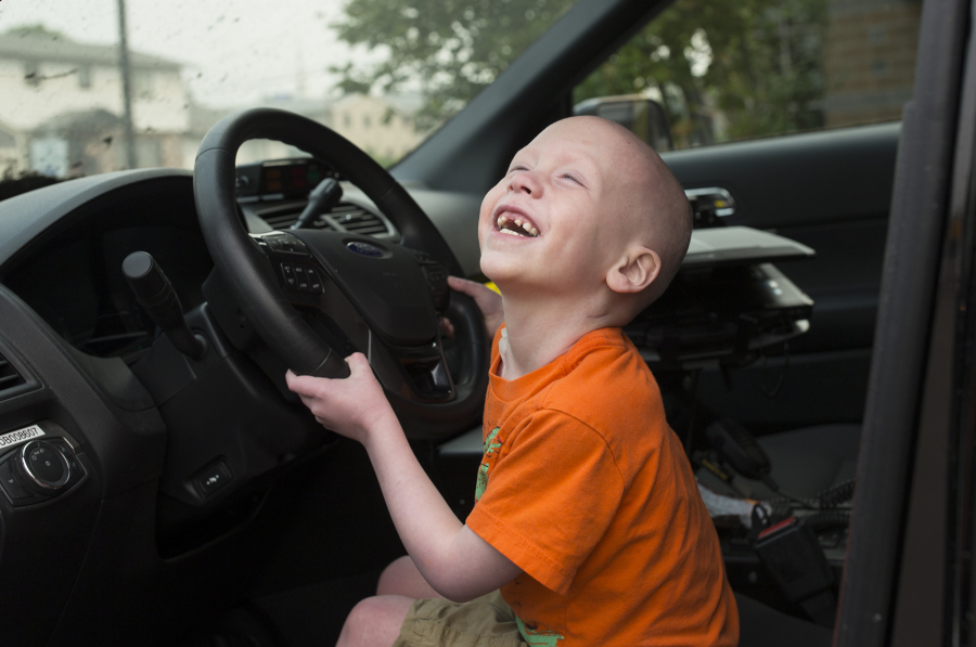 Declan Reagan plays inside his dad’s police cruiser at the Washougal Police Department in Washougal in 2017. A woman from England had donated her bone marrow for his transplant. He died Friday.