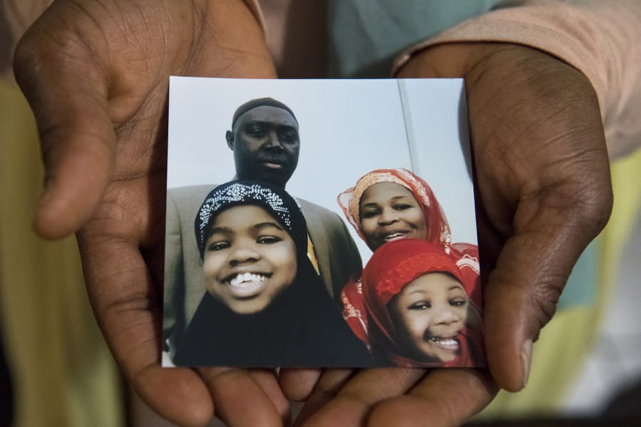 Wilitha Jarju holds a photo of her family at their home in Vancouver on Tuesday. After living in the U.S. for 17 years, Wilitha Jarju’s husband, Gibril Jarju, was taken from their home by ICE on Feb. 23 and transported back to The Gambia.