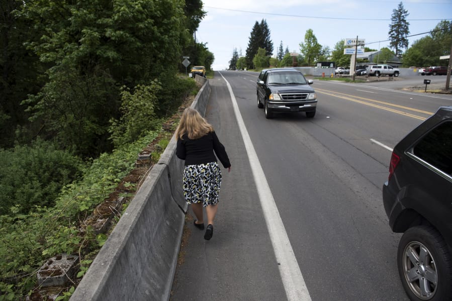 Vicki Fitzsimmons walks along what she calls a “pinch point” on Northeast Highway 99 where the sidewalk ends, forcing pedestrians to walk in a bike lane a few feet from fast-moving traffic.