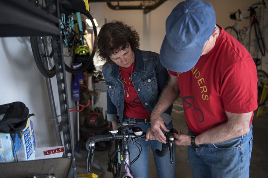 Lilly Boulianne, left, and her husband Dave Halstead, both of Vancouver, attach a bell to Boulianne’s bike Friday afternoon as they load up their RV. This will be their first cross-country cycling trip.