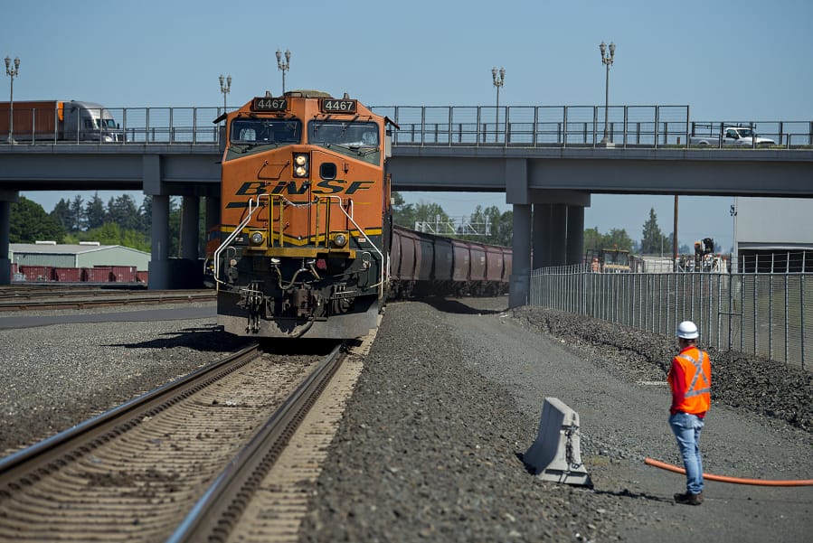 BNSF Railway spokesman Gus Melonas pauses to look over a train hauling grain as it is parked in BNSF’s Vancouver yard last week. BNSF reported that it moved a record volume of material in the first quarter of this year.