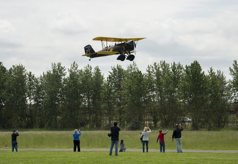 A 1930 Stearman Speedmail vintage biplane takes flight over spectators while carrying mail from Pearson Airfield on Friday morning, May 18, 2018. The flight commemorated the centennial of airmail service.