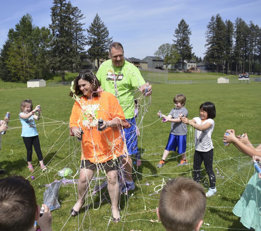 Washougal: Gause Elementary School Principal Renae Burson and physical education teacher Mark Bauer are sprayed with aerosol string by Cecilia Goodling’s kindergarten class to celebrate the class’ efforts during a fundraiser for the American Heart Association.
