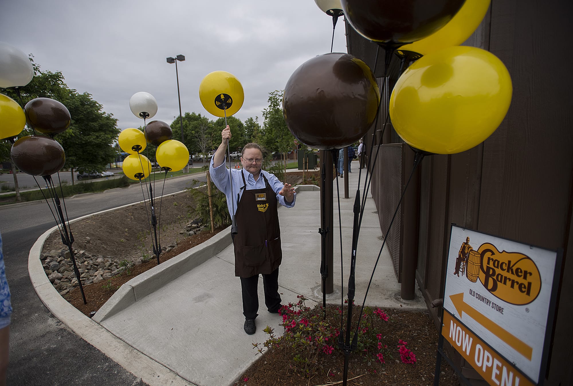 Guest services representative Serena Branner helps decorate the exterior of the new Cracker Barrel in Jantzen Beach for customers Monday morning, May 21, 2018.