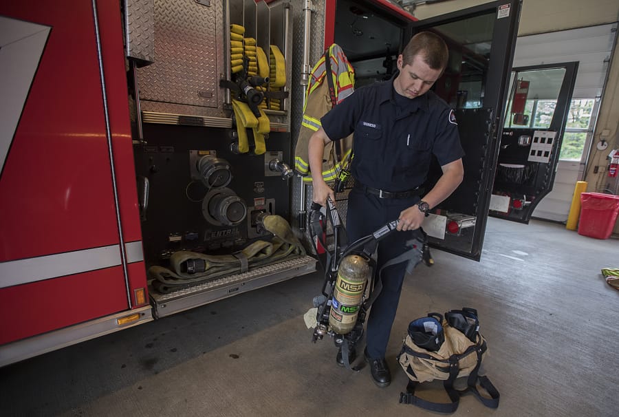 Intern firefighter Joel Vanness displays a self-contained breathing apparatus that firefighters use at East County Fire and Rescue in rural east Clark County. An increase in call volume and property values are stretching East County Fire and Rescue’s budget and the department is thinking about asking to put a levy lid lift up for vote just to maintain service. The chief said that if the vote passes, they might look to replace the air packs firefighters use when entering a burning structure and the jaws of life on some engines.
