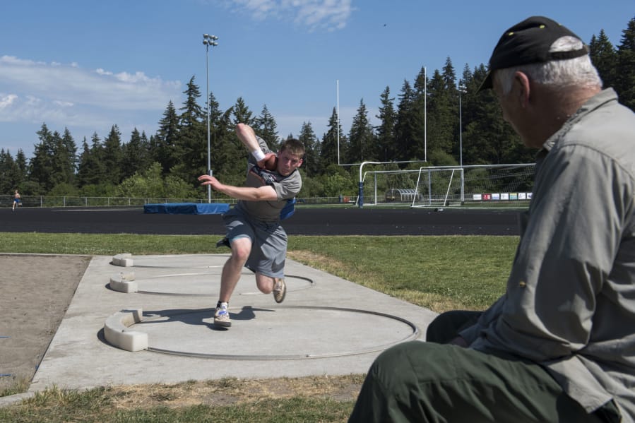 Ridgefield High School sophomore Trey Knight practices the shot put after school with his coach and grandfather John Gambill of Vancouver on Wednesday, May 23, 2018.