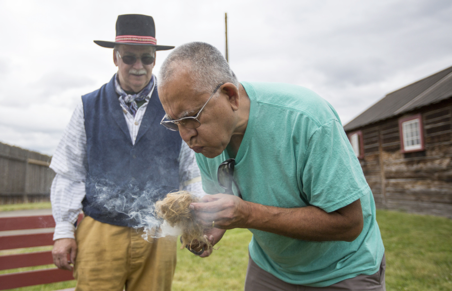 Volunteer Terry Wynkoop, left,  helps Jose Palmas use flint and steel to build a fire at Fort Vancouver Saturday.