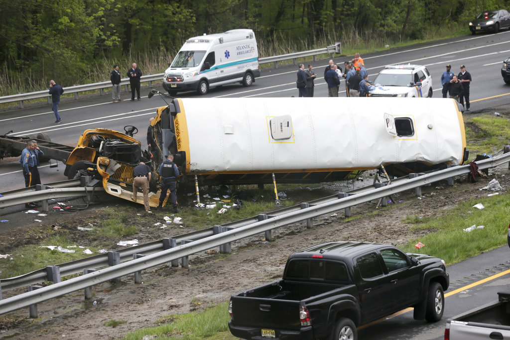 Emergency personnel work at the scene of a school bus and dump truck collision, injuring multiple people, on Interstate 80 in Mount Olive, N.J., Thursday, May 17, 2018.