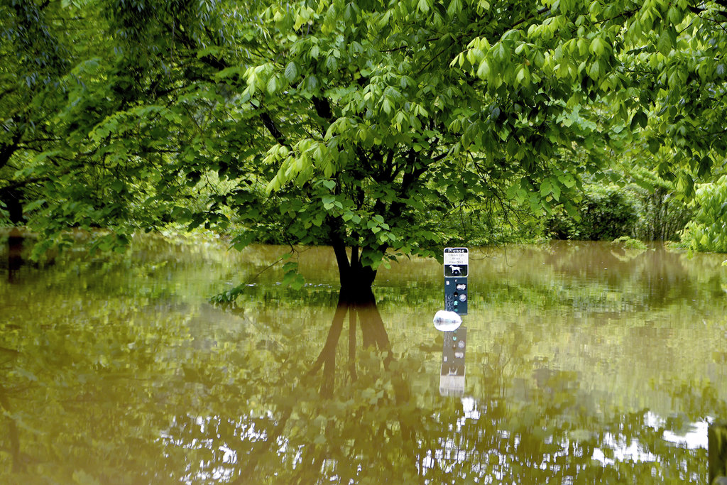 A sign sticks out of the water from the French Broad River that flooded into Carrier Park in Asheville, N.C., Wednesday, May 30, 2018.  The soggy remnants of Alberto spread rain deeper into the nation's midsection after downing trees, triggering power outages and scattering flooding around the South.