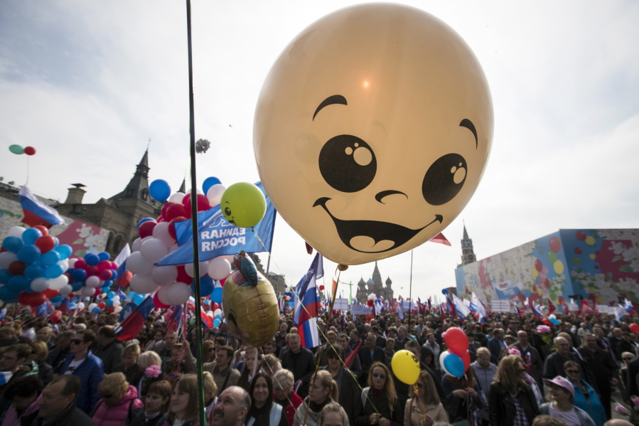 Balloons and flags fly over the crowd as people walk on Red Square to mark May Day in Moscow, with St. Basil’s Cathedral center in the background, Russia, Tuesday, May 1, 2018. As in Soviet times, people paraded across Red Square, but instead of red flags with the Communist hammer and sickle, they waved the Russian tricolor.