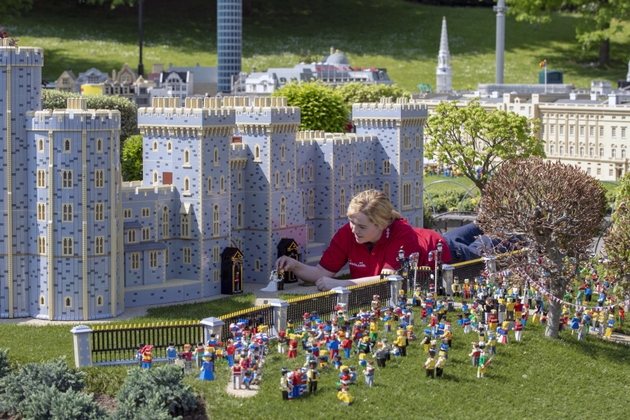 Model maker Lucy Gullon puts the finishing touches on a Lego depiction of the upcoming royal wedding, complete with a 39,960- brick version of Windsor Castle, on Tuesday in Legoland Windsor, England. The model took eight model makers 592 hours to build.