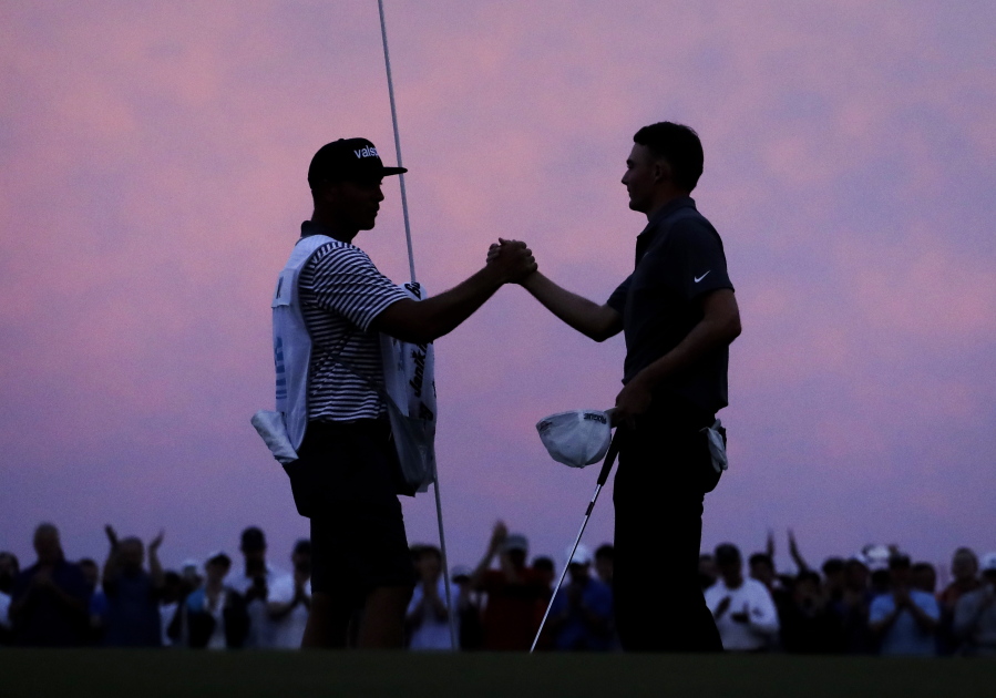 Caddie Brian Dilley, left, congratulates Aaron Wise after Wise won the AT&T Byron Nelson golf tournament in Dallas, Sunday, May 20, 2018.