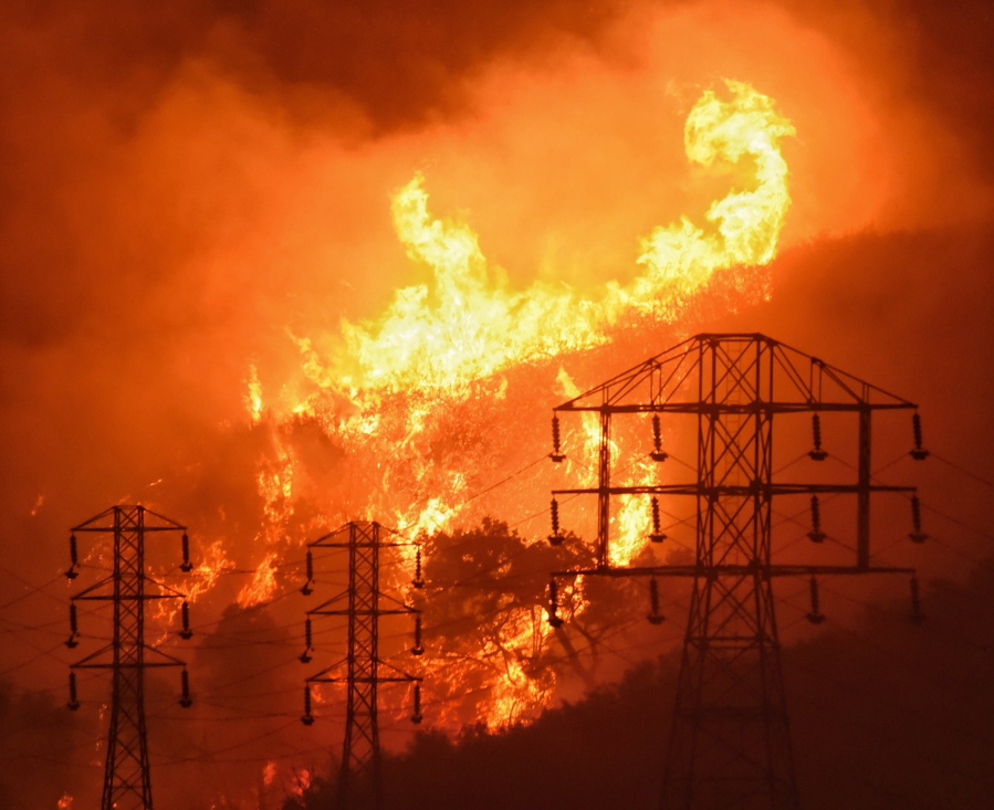 A fire rages near power lines Dec. 16, 2017, in Montecito, Calif. State fire officials blamed power lines coming into contact with trees for sparking four Northern California wildfires.