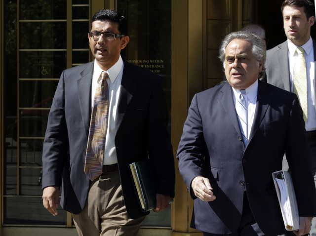 In this May 20, 2014 file photo, conservative scholar and filmmaker Dinesh D'Souza, left, accompanied by his lawyer Benjamin Brafman leaves federal court, in New York. President Donald Trump says he will pardon conservative commentator Dinesh D'Souza who pleaded guilty to campaign finance fraud. Trump tweeted Thursday: “Will be giving a Full Pardon to Dinesh D’Souza today. He was treated very unfairly by our government!” D’Souza was sentenced in 2014 to five years’ probation after he pleaded guilty to violating federal election law.