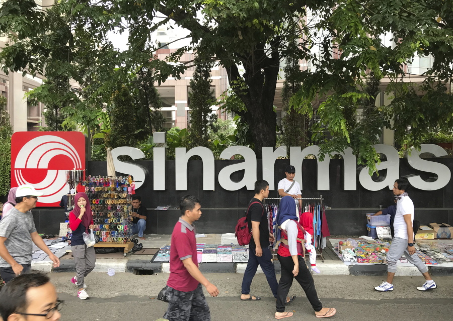 People walks past Sinarmas Land Plaza during a car-free day at the main business district in Jakarta, Indonesia. Greenpeace has ended a five-year truce with one of the world’s largest pulp and paper companies, accusing it of cutting down tropical forests in Indonesia during the entire time the two were cooperating on conservation.